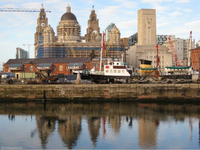 Image of the Liverpool skyline reflecting in the water at Albert Dock in Liverpool England.
