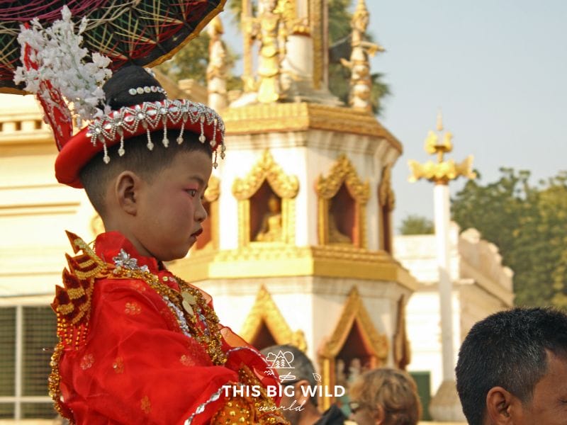 Image of a young boy dressed in opulent clothing in a Shinbyu Parade near Bagan Myanmar. After the parade he will leave his family to become a novice monk.