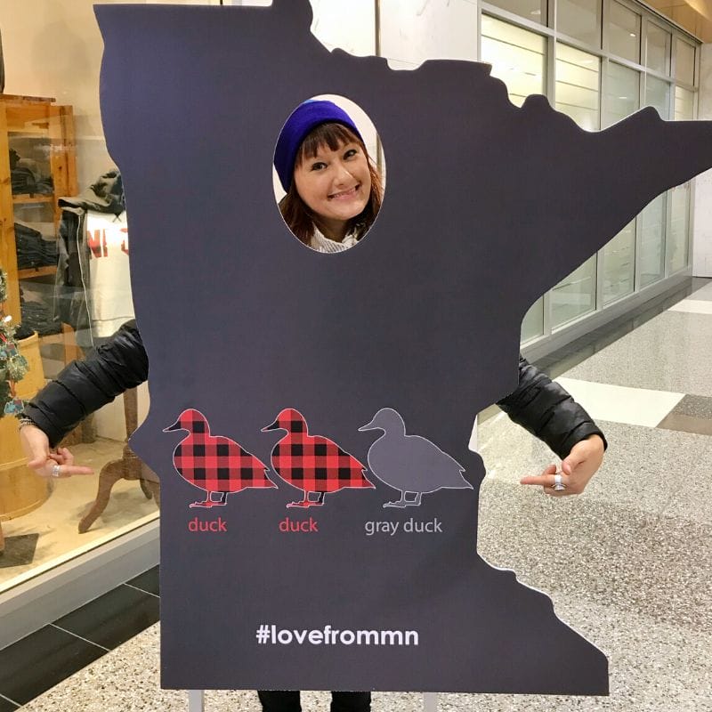My face poking through a cutout of Minnesota with "duck duck gray duck" written on it, proof that Minnesotans refuse to call the childhood game "duck duck goose" like the rest of the US.
