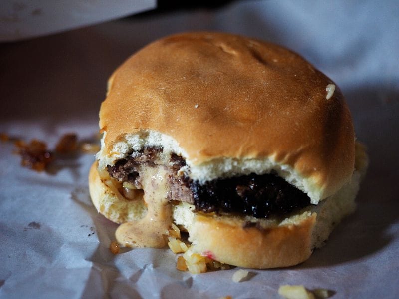Cheese melts out of the inside of a Jucy Lucy burger at Matt's Bar in Minneapolis. Photo by Erin from Due Midwest travel blog.
