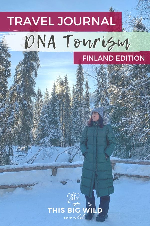 Me, a woman, standing in front of snow covered pine trees with sun peeking behind them. The ground is covered in snow and I am wearing a puffy green knee length winter jacket and big gray winter hat. Text: Travel Journal DNA Tourism Finland Edition