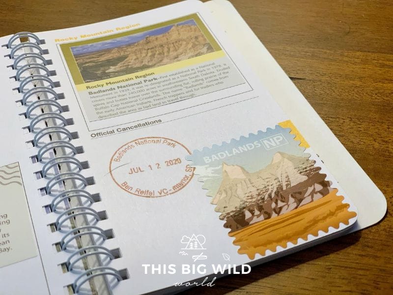A close up page in my National Parks passport. On the top half of the page is the Rocky Mountain Region sticker, which is purchased at the park visitor center. One the lower half is a date stamped (July 12 2020) Badlands National Park stamp and an artistic sticker purchased in the visitor center. 