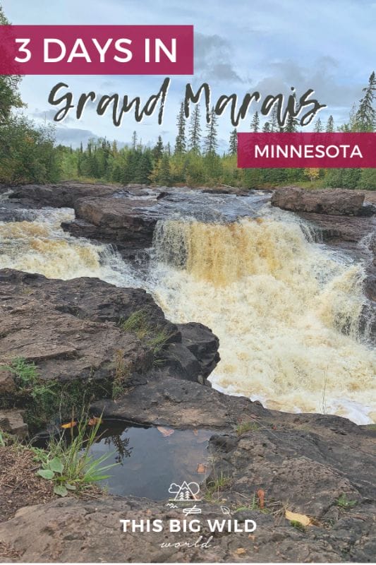 Text: 3 Days in Grand Marais Minnesota
Background Image: Wide waterfalls flows over brownish red rocks with smaller waterfalls overflowing on either side. In the distance is a line of green and yellow trees with a bright blue sky overhead.