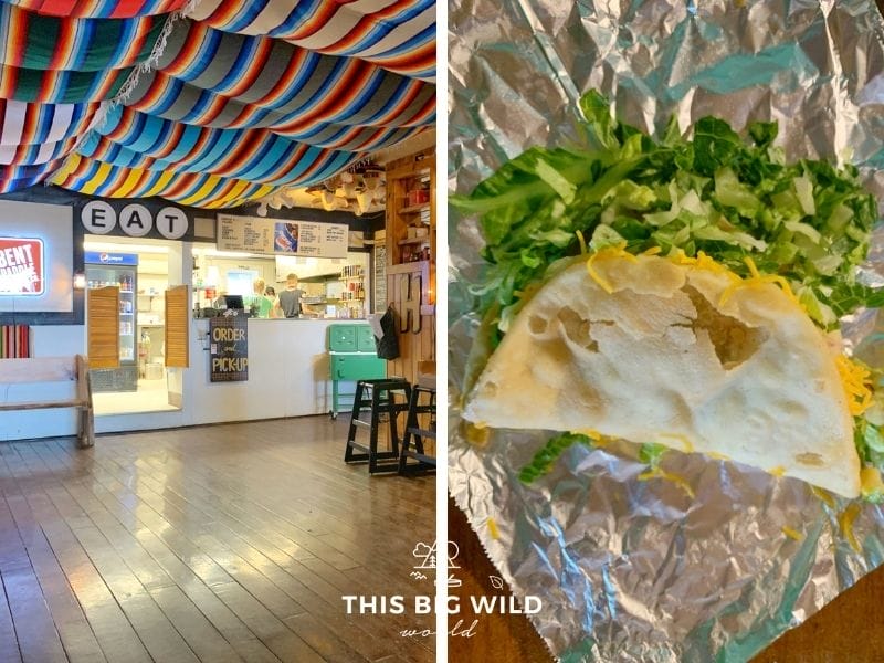 Left: Inside of Hungry Hippie Tacos there are wooden floors and colorful blankets draped from the ceiling. There's a small counter where you place your order.
Right: An upclose picture of a frybread taco which looks like a deep fried taco shell folded in half with cheese and lettuce coming out of it sitting on a piece of aluminum foil.