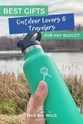 Text: Best Gifts Outdoor Lovers & Travelers for any budget! Image: Mint green water bottle is held up in front of a lake with tall yellow grass growing around it.