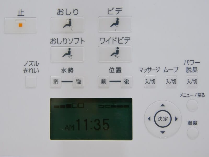 An up close view of the keypad on a Japanese bidet. There are several buttons with Japanese symbols and icons for spraying water and air as well as flushing the toilet.