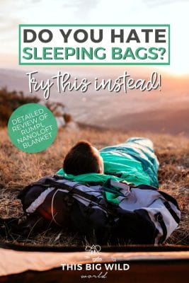 Text: Do you hate sleeping bags? Try this instead! Detailed review of Rumpl Nanoloft Blanket. Image: Person laying in a sleeping just outside of a tent watching the sunrise off in the distance.