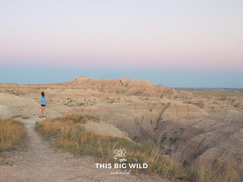 Me wearing a lightweight long sleeve blue top with black shorts at sunset in Badlands National Park in summer.