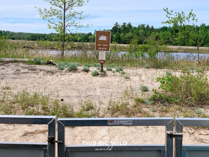 A brown rectangular sign with a houseboat symbol on a beach in Voyageurs National Park in Minnesota, designates a houseboat site.