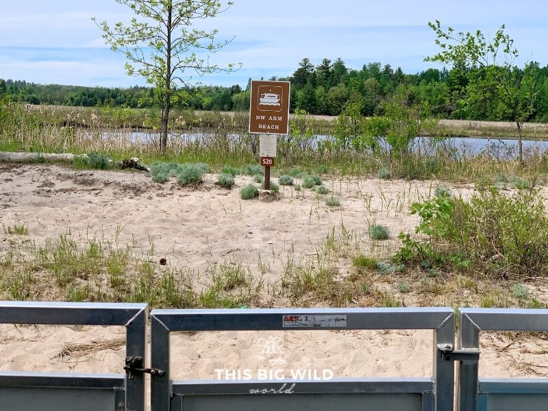 A brown rectangular sign with a houseboat symbol on a beach in Voyageurs National Park in Minnesota, designates a houseboat site.