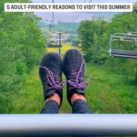 Text: Spirit Mountain, Duluth - 5 Adult-Friendly Reasons to Visit This Summer; Image: My feet stretched out while riding the chair lift at Spirit Mountain in Duluth MN with a view of Lake Superior.
