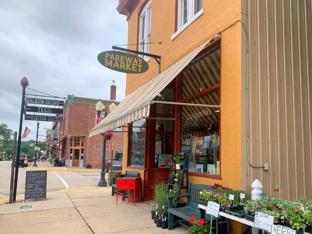 A corner grocer, Parkway Market, with sidewalk seating in downtown Lanesboro MN.