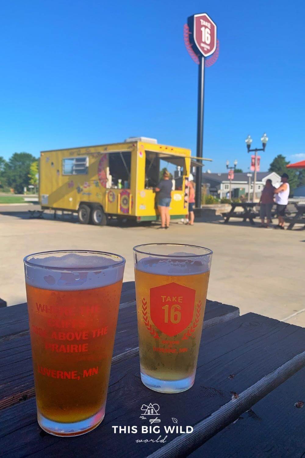 Two beers on a picnic table at Take 16 Brewery with a food truck in the background.