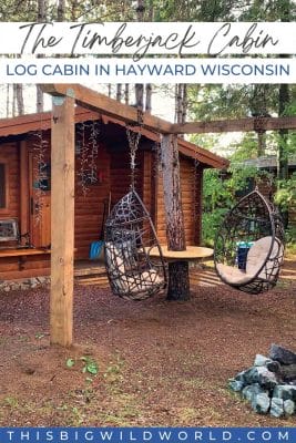 Text: The Timberjack Cabin - Log Cabin in Hayward Wisconsin. Image: Log cabin in the forest with floating chairs next to a fire pit.