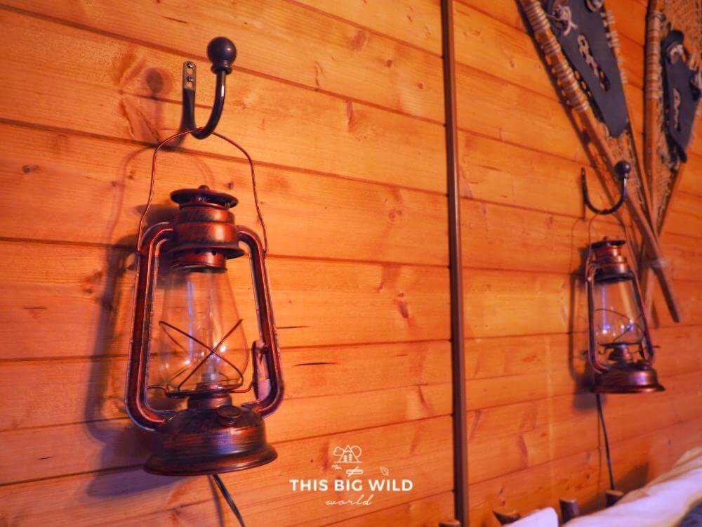 The decor at The Timberjack at Hayward Cabins is lumberjack and northwoods themed, like these metal lanterns above the bed.