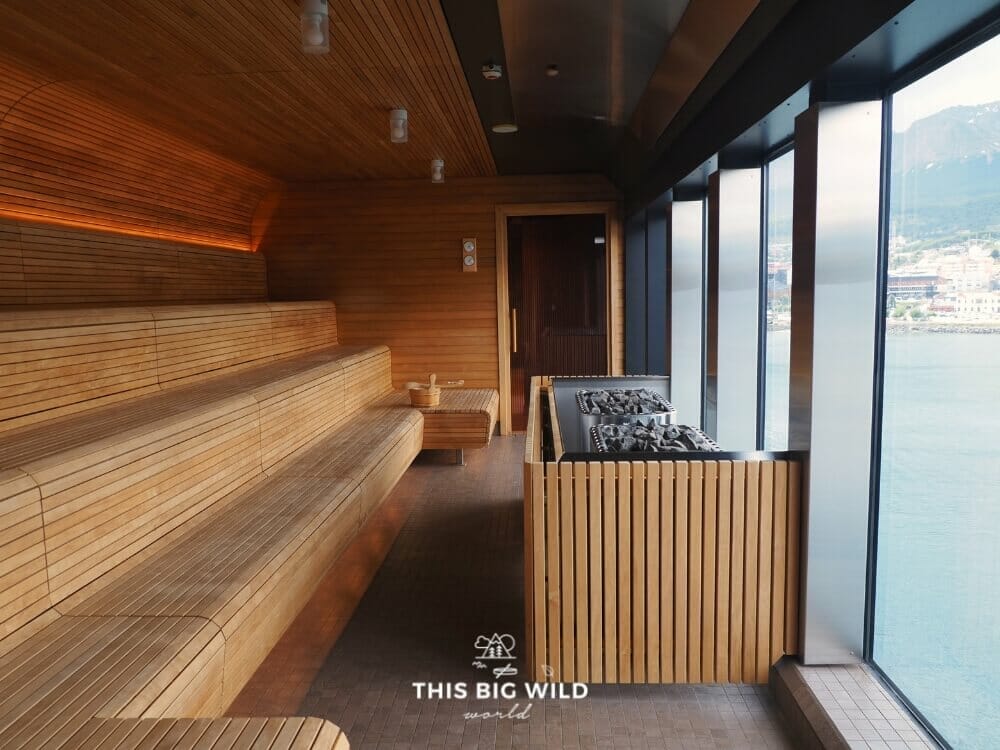 Wooden sauna benches look out towards a wall of windows on board Hurtigruten's MS Fridtjof Nansen ship.