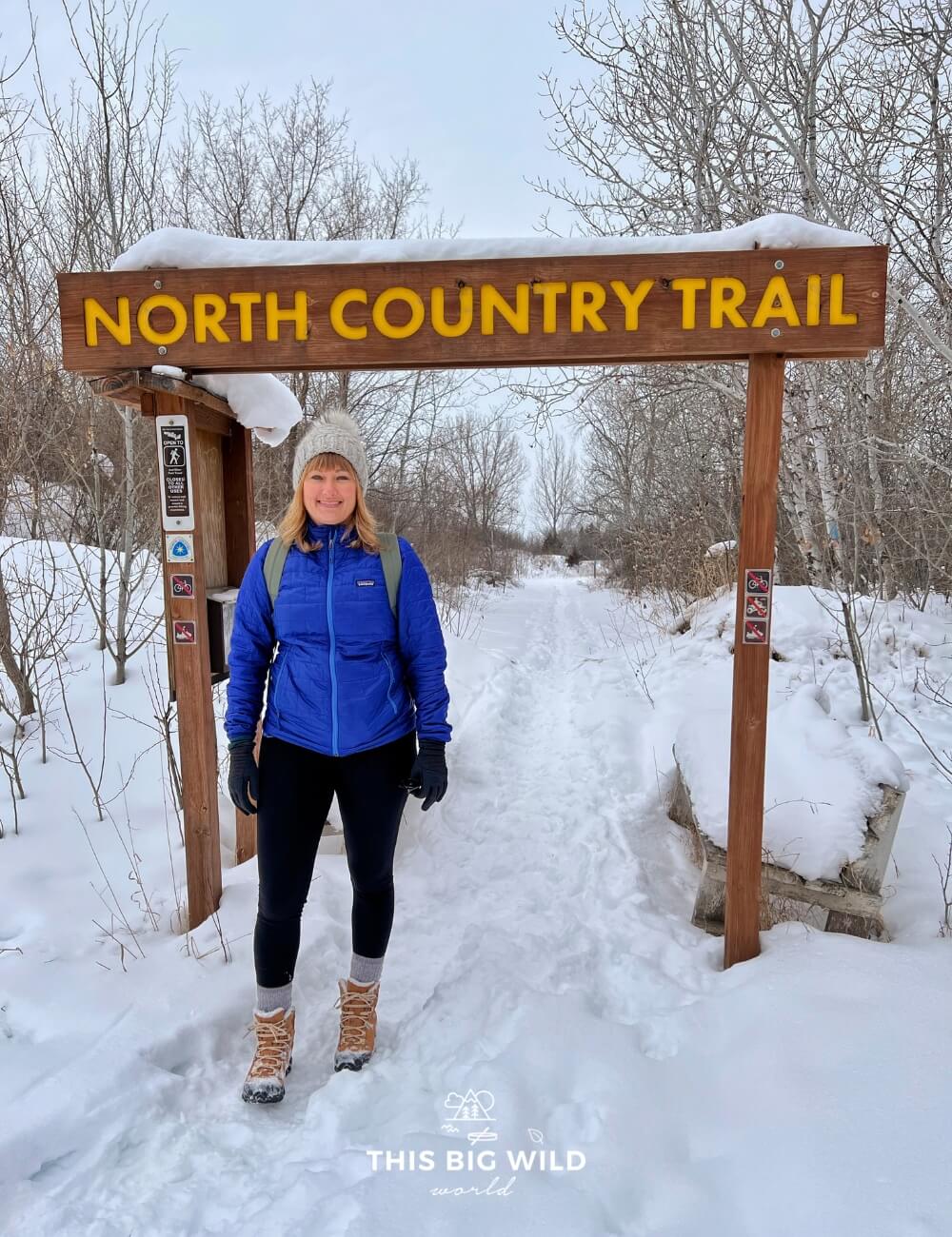 Me standing in front of the North Country Trail sign in Fergus Falls in winter.