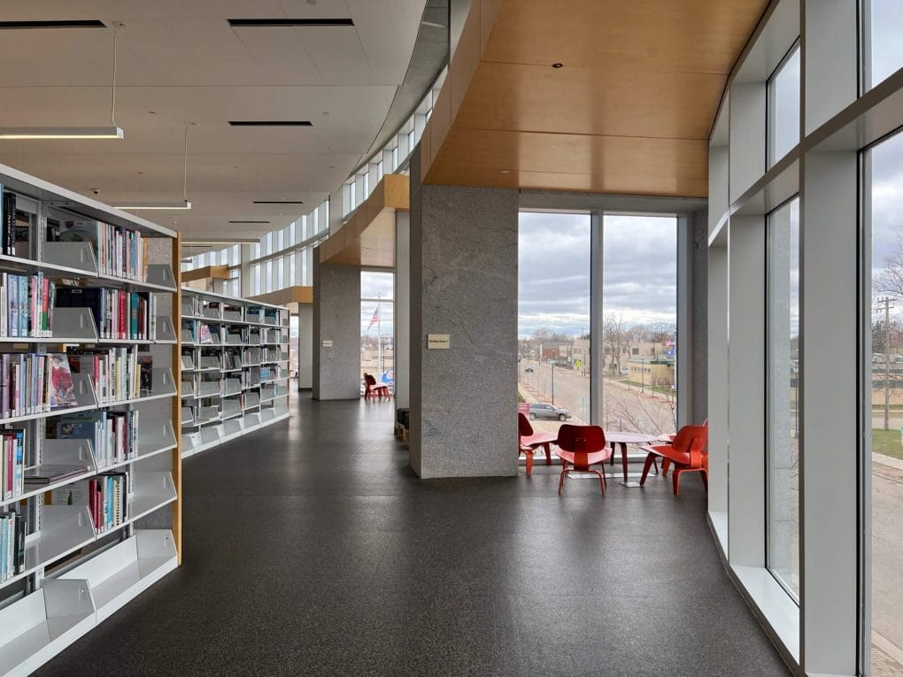 Reading nook next to a wall of windows at the St Cloud Public Library