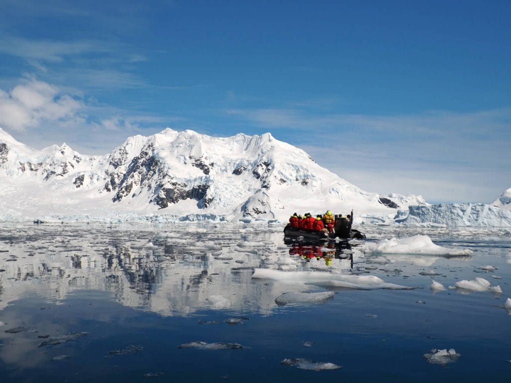 A zodiac boat cruises through sea ice in early December in Antarctica.