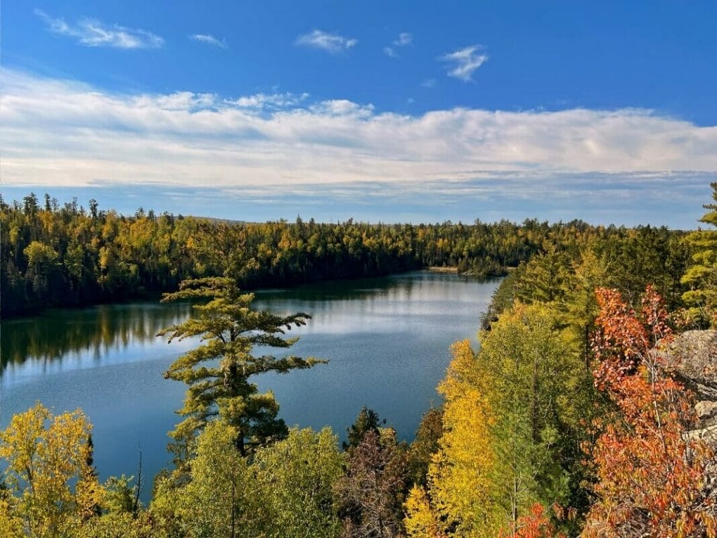View of Ennis Lake from above with yellow and red leaves in the foreground near Ely Minnesota.