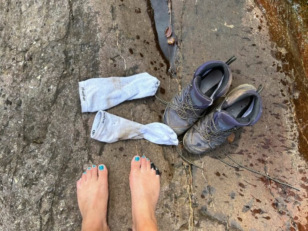 Removing my toe socks and hiking boots to rest near a river on the Superior Hiking Trail.