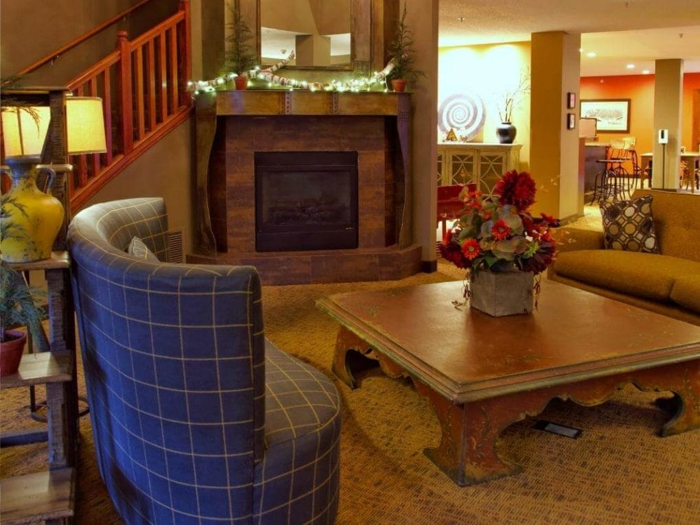 The lobby at the GrandStay La Crosse is cozy and inviting with comfy seating around a fireplace.