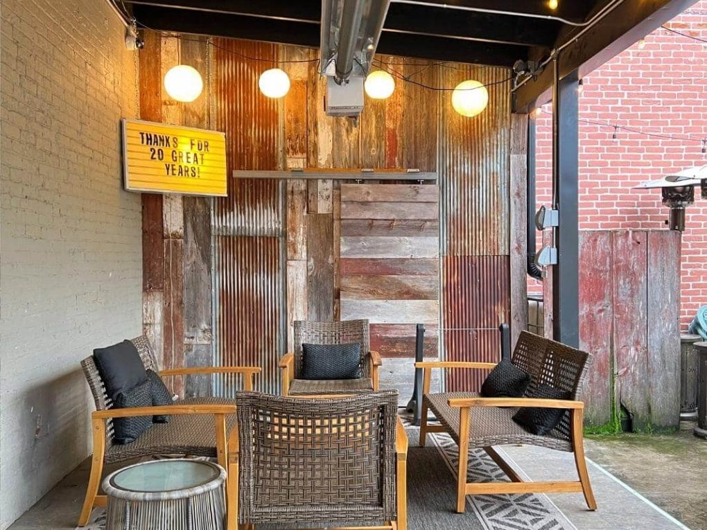 Covered outdoor patio space at Ground Patio Cafe in La Crosse has rustic finishes and comfy lounge seating.
