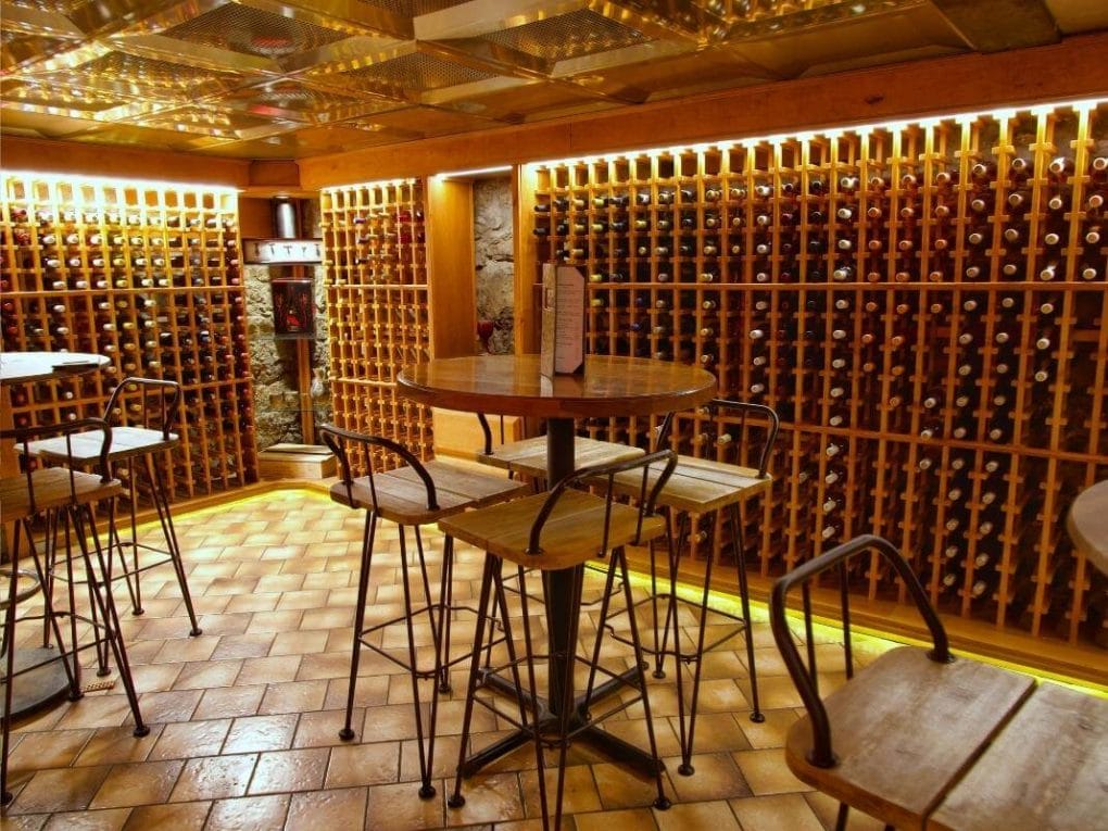 La Cave has two rooms off of the main bar, each with walls lined in bottles of wine and tables for seating.