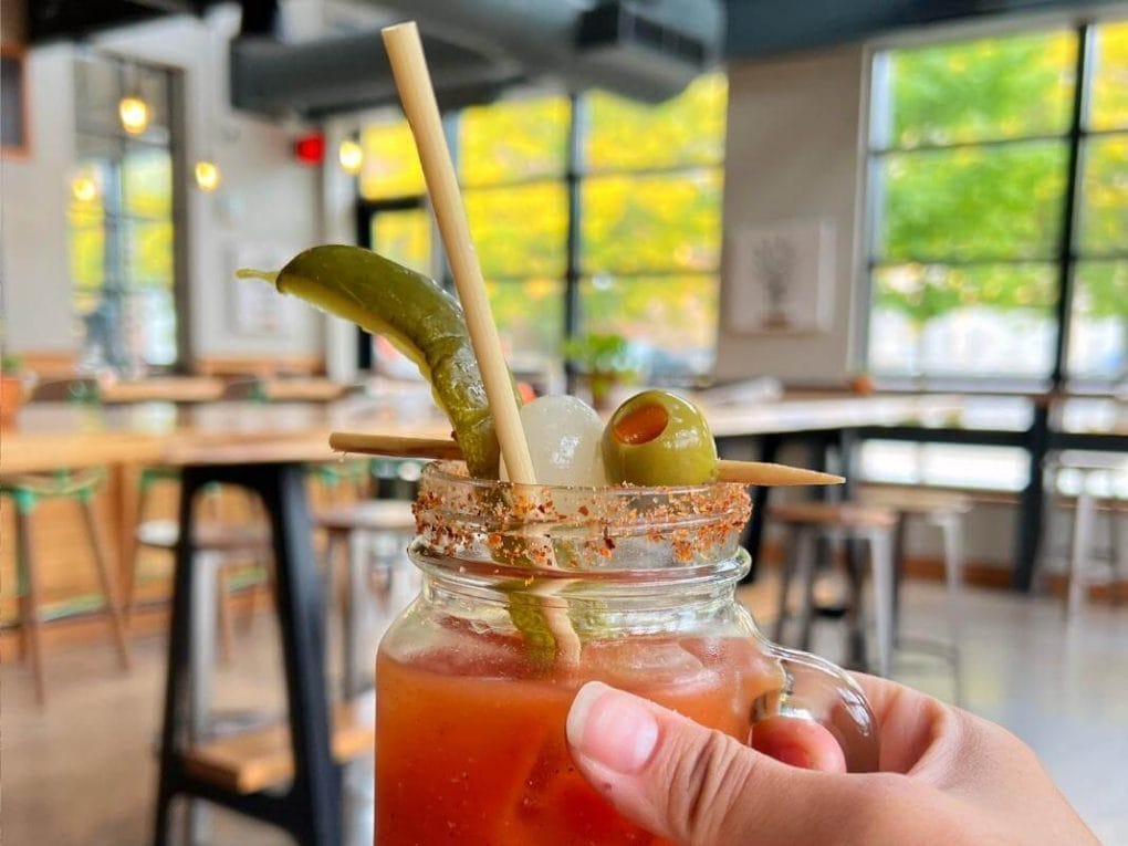 Holding up a Bloody Mary inside the bright and modern space at La Crosse Distilling Co.